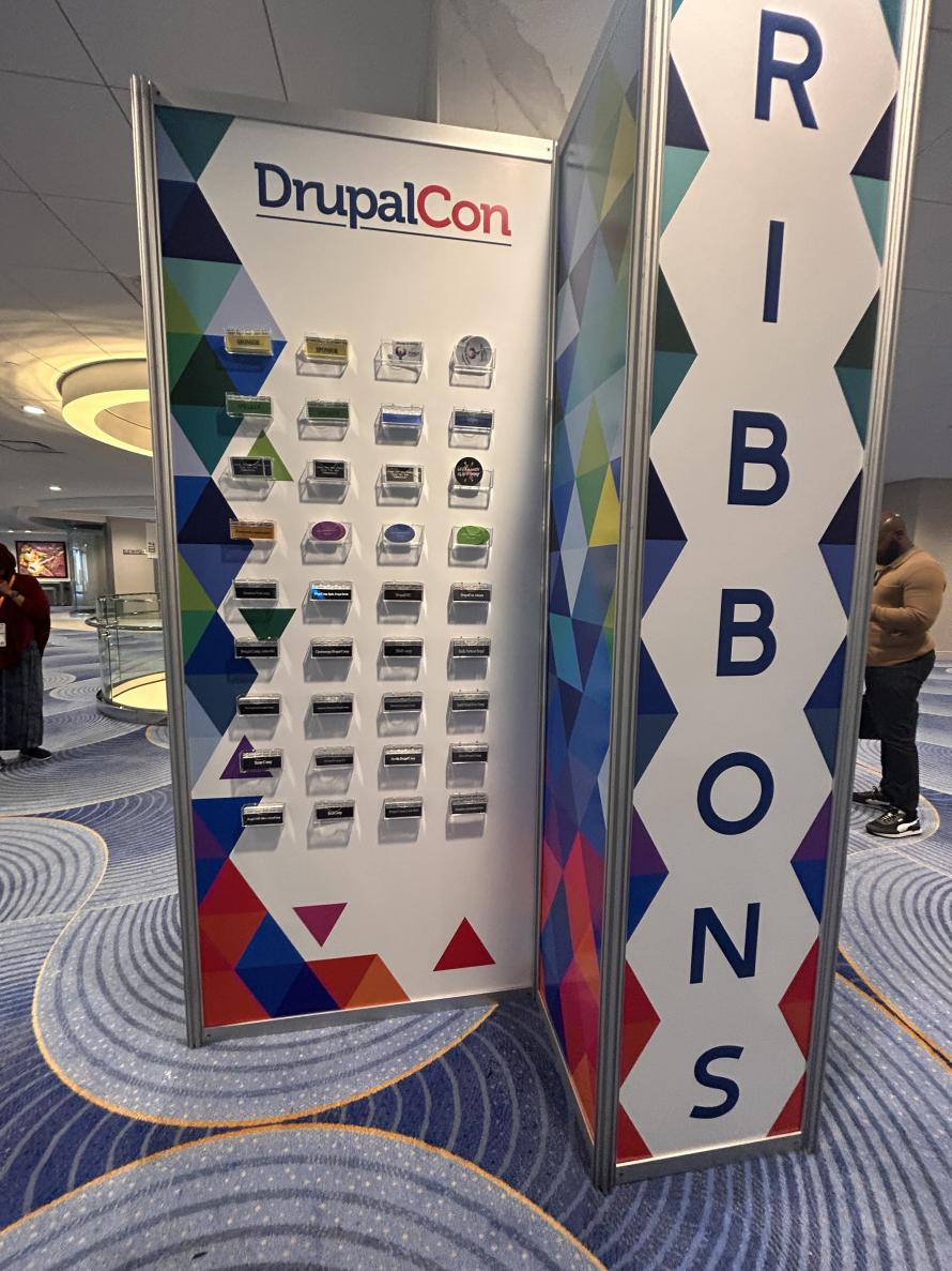 Ribbons and stickers display at DrupalCon Atlanta 2025